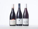 three bottles of wine are lined up on a table