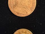 two different types of gold coins on a black surface