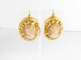 une paire de boucles d'oreilles dorées ornées d'un camée