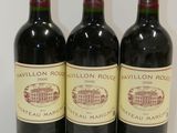 three bottles of red wine are lined up on a table