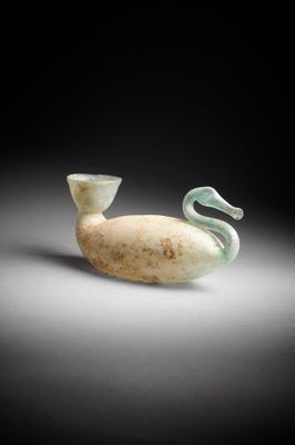 un vase en verre blanc et vert posé sur une table