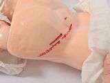 a dummy with a bandage on it and a hand holding it
