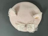 a pink hat with a white bow on top of it