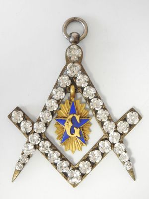 une image représentant un pendentif maçonnique en forme d'équerre et de compas, de couleur bleue et dorée