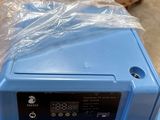 a blue box with a clock on top of it in a warehouse