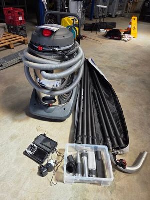a vacuum that is sitting on the floor next to a bunch of hoses
