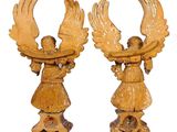 pair of carved wooden angel figurines with wings on pedestal