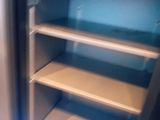 a refrigerator with shelves in the corner of the room