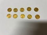 a bunch of gold coins sitting on top of a white table