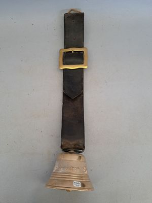 une horloge accrochée au mur, à laquelle est suspendue une cloche