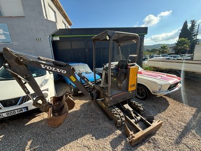 a small excavator parked in front of a building