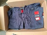 two pairs of men ' s pants in a cardboard box on a floor