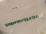 a white blanket with a green logo on it in a store