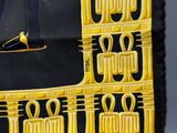 a black and yellow tie with an egyptian design on it