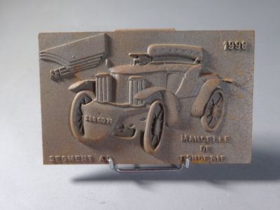 a belt buckle with a picture of an old car on it