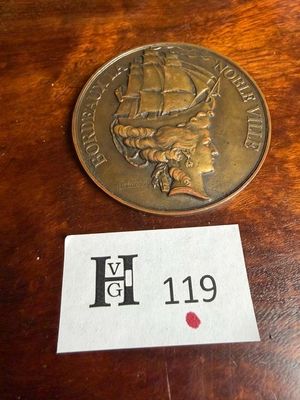une pièce de monnaie posée sur une table, sur laquelle est posé un badge nominatif