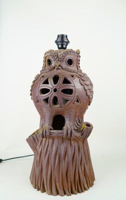 a birdhouse made out of a tree stump with a lamp on top