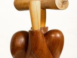 a wooden sculpture of a heart with two sticks sticking out of it