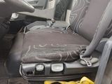 a seat in the back of a truck with a bag of luggage on it