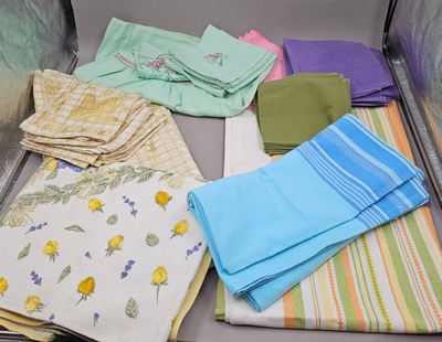 de nombreuses serviettes pliées rangées dans une valise posée par terre