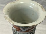 un vase blanc orné d'un motif posé sur une table