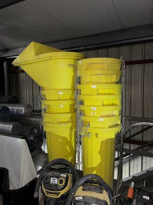 Des seaux jaunes sont empilés les uns sur les autres dans un garage