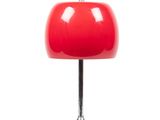 La lampe de table rouge repose sur un pied trépied en métal.