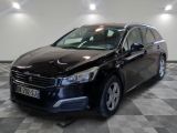 la voiture noire est garée sur un sol en damier dans le garage