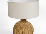 a rattan lamp with a white shade on top of it