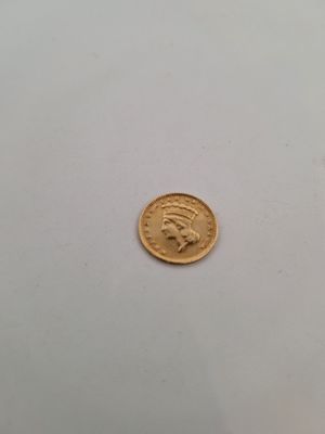 gros plan d'une pièce d'or avec un visage dessus