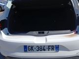 the back of a white car with its trunk open in a parking lot