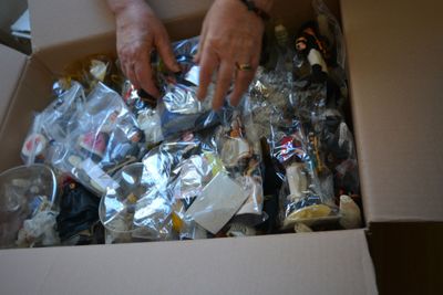 a person that is opening a box full of assorted items