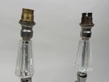 two glass candlesticks that are on a table