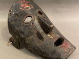 un masque en bois percé d'un trou au milieu
