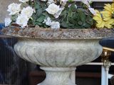 a large stone vase with flowers in it on a table