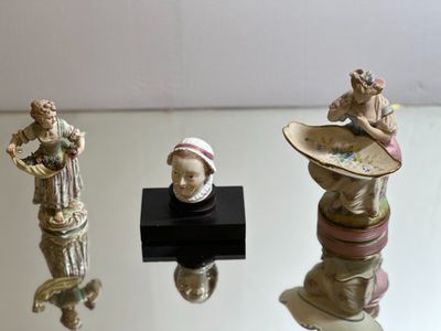 three figurines that are sitting on a glass table