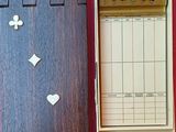 une boîte en bois contenant un jeu de cartes, posée sur une surface rose
