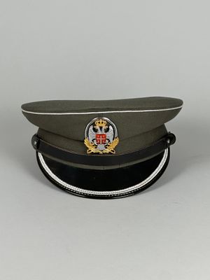 une casquette militaire ornée d'un insigne, posée sur une table