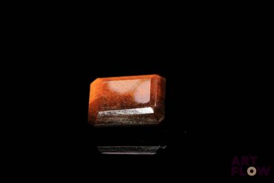 un gros plan d'un morceau de quartz orange sur une surface noire