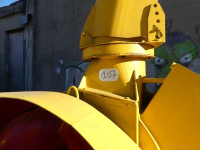 a close up of a yellow traffic light with graffiti on the wall