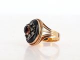 an image of a gold ring with a black stone surrounded by diamonds