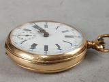 a gold pocket watch with roman numerals on it