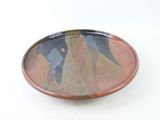 a plate with a painting on it on a white surface