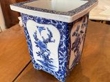 a blue and white vase sitting on a wooden table