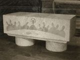 an old photo of a stone bench with a group of people on it
