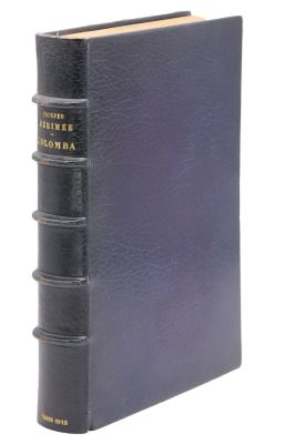 un vieux livre à la couverture noire posé sur une surface blanche