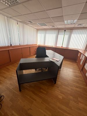 un bureau avec une chaise et une étagère dans le coin