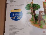 a cardboard box with a picture of a dinosaur and a tree