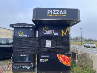 un kiosque à pizza sur lequel est posée une pizza