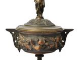 an image of a bronze vase with a boy on top of it